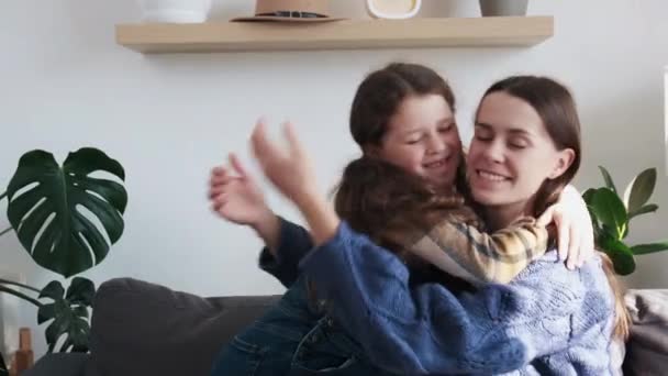 可爱的小女孩拥抱拥抱快乐的年轻妈妈表现出爱心和爱心 迷人的微笑的妈妈和滑稽的小女儿在家里开心地拥抱在一起分享温馨的时光 — 图库视频影像