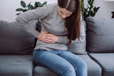 Seçici odak noktası karın ağrısı çeken genç bir kadın. Gıda zehirlenmesi, karın ağrısı ve kolon sorunu, mide iltihabı veya ishal. Hasta karnı, karın bölgesi ya da iltihap konsepti