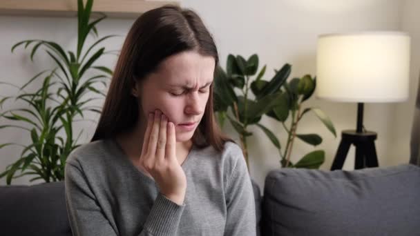 Genç Beyaz Kadın Yanağına Dokunuyor Evdeki Koltukta Otururken Dişleri Ağrıyor — Stok video