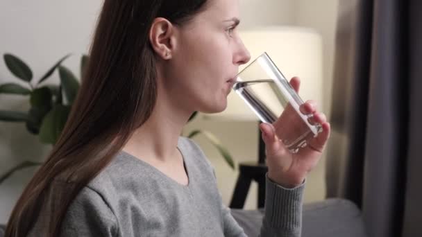 歯痛を患っている若い女性 氷の頬で水のガラスを保持している女の子 顔の表情の痛みや痛みを感じる 敏感な臼歯の歯 冷たい飲み物の炎症 医療の概念 — ストック動画
