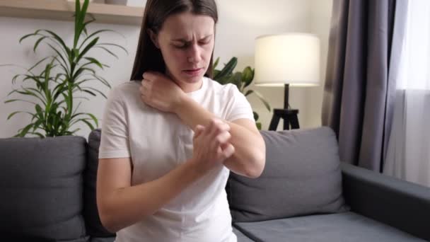 一个不健康的年轻女人坐在沙发上 皮肤发痒 身体发痒 身体发痒 对昆虫叮咬 皮炎的过敏反应 卫生保健概念 过敏性皮疹 — 图库视频影像