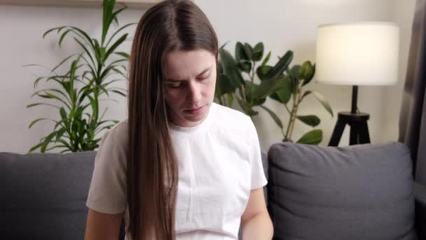 Zdenerwowana Młoda Kobieta Siedząca Kanapie Szczotkująca Włosy Nieszczęśliwa Kobieta Robi — Wideo stockowe