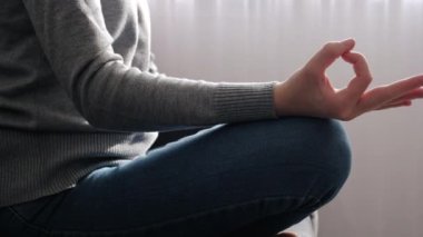 Kanepe nilüferinin rahat pozunda oturan genç bir bayanın elini kapat, meditasyonun tadını çıkar evde oturma odasında yoga yap. Stres yok, sağlıklı alışkanlık yok, farkındalık yaşam tarzı yok, endişe giderme konsepti yok.