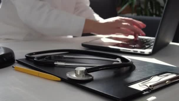Selektivní Zaměření Stetoskopu Pozadí Profesionální Lékařka Bílém Plášti Pomocí Notebooku — Stock video