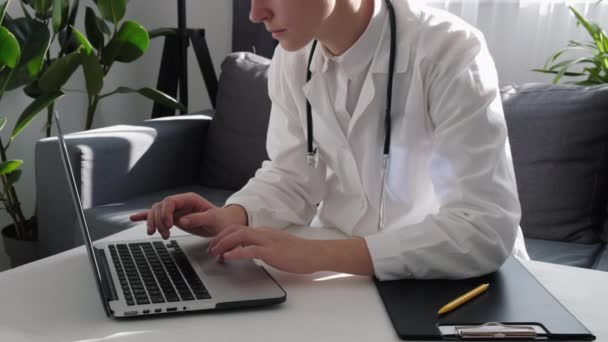 Médica Médica Jovem Séria Pensativa Sentada Mesa Trabalho Escritório Laptop — Vídeo de Stock