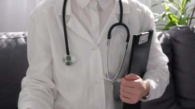 Steteskoplu beyaz üniformalı kadın doktor elinde kağıt sarısı üzgün bir ifade ve kanepede oturan bir pano tutuyor. Geribildirim derecelendirme ve müşteri değerlendirmesi, deneyim, memnuniyet anketi kavramı