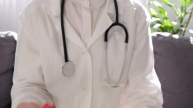 AIDS, HIV konsepti. Küçük kırmızı göğüs kanseri sembolü taşıyan profesyonel kadın doktorlara yakın çekim. Hastalıklı insanları destekliyor. Farkındalık, yardım, sağlık, yardım ve umut