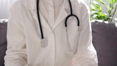 Ekim Kanser Farkındalığı Ayı. Doktor kadının elinde yaşayan ve hastalığa yakalananları desteklemek için küçük pembe bir kurdele tutmasına yakın çekim. Sağlık, Uluslararası Kadınlar Günü ve Dünya Kanser Günü konsepti