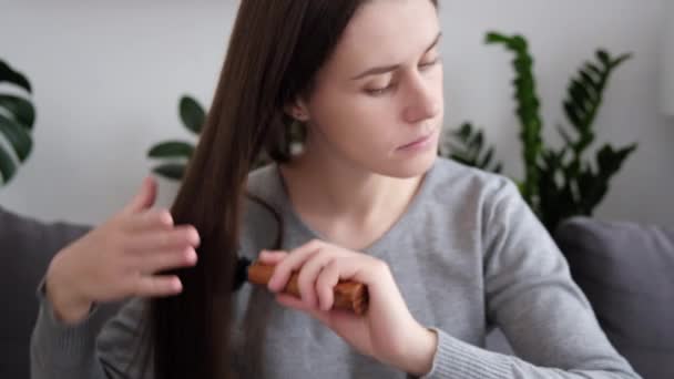 Вибірковий Фокус Молодої Жінки Сидить Дивані Чистити Волосся Допомогою Інструменту — стокове відео