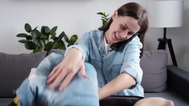 Glad Kvinna Diskuterar Resväska Förpackning Kläder Organisation Smartphone Sitter Soffan — Stockvideo