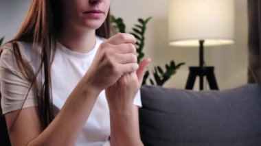 Parmaklarım ağrıyor. Eklem iltihabı ve parmaklarında eklem ağrısı olan hasta genç bir kadın evdeki kanepede oturuyor. Kronik gut belirtileri gösteren kadın elinin yakın çekimi. Sağlık hizmeti kolay kendine masaj konsepti