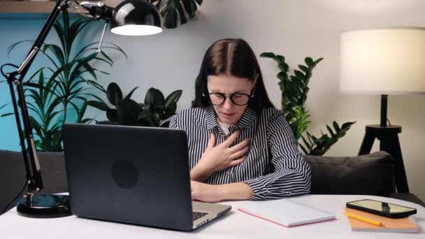 呼吸急促胸痛在电脑上工作的眼镜少女的特写 呼吸困难或胸部疼痛用手触摸胸部 恐慌发作哮喘骨质疏松症的概念 — 图库视频影像