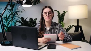 Kameraya konuşan kendine güvenen genç bayan kanepeye otur. Sosyal medya kanalı için internet öğretmeni, blogcu ve danışman podcast 'i. Uzak çevrimiçi satıcı apartmandan sunum yapıyor