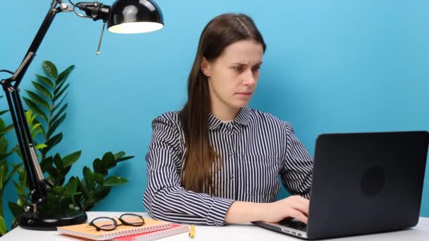 厳格な従業員ビジネス女性の肖像20歳はスタジオで青の背景色の壁の上に隔離されたポーズ ノートパソコンを保持ストップジェスチャー手でオフィスデスクで仕事に座っています 事業概念 — ストック動画