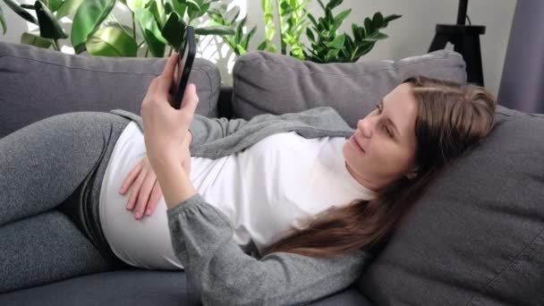 Relaxed Peaceful Smiling Young Woman Big Belly Lying Comfy Sofa — Stockvideo