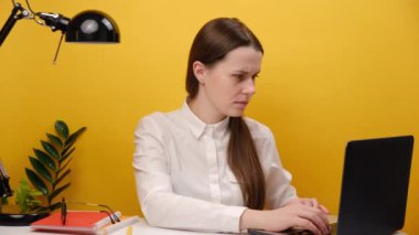 Angry wondered employee IT business woman in casual white shirt sit work at office desk using laptop spread hands, posing isolated on yellow color background wall in studio. Achievement career concept