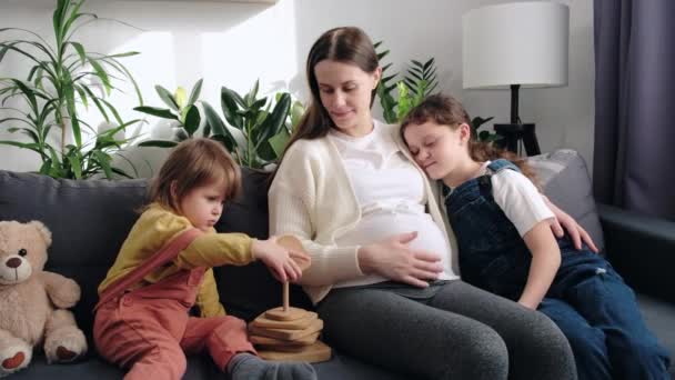 Loving Pregnant Mom Two Adorable Little Daughters Playing Cozy Couch — Vídeo de stock