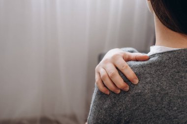 Side view of unhealthy young brunette female 20s suffering from pain in shoulder, doing self-massage. Neck pain. Forearm pain, people with body muscle problems, healthcare and medicine concept