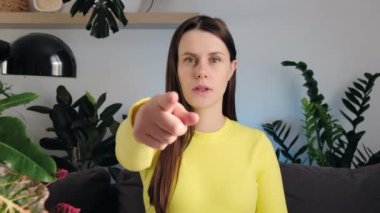 Birini işaret eden genç bir kadın portresi. Kasvetli negatif beyaz kadın 20 'li yaşlarda kameraya bakar ve birini işaret eder ve oturma odasında kanepede oturduğunu söyler. İnsanların duygu kavramı