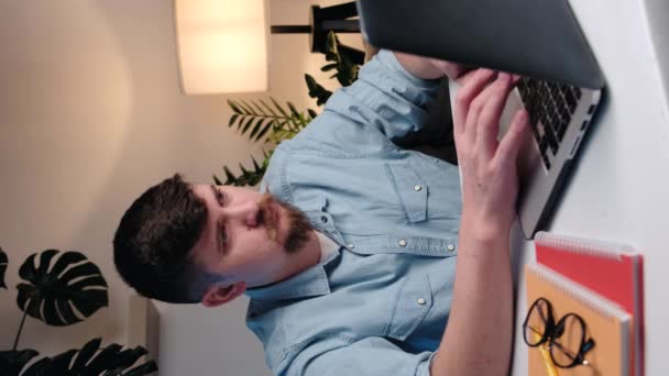 一个悲伤的30多岁的白人男子在笔记本电脑上工作的垂直视频 她的肘部感到疼痛 并试图伸展她的肌肉和手部关节 关节炎 毛囊炎的概念 肘部疼痛 — 图库视频影像