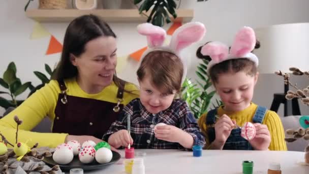 Kochająca Młoda Matka Dwie Szczęśliwe Córeczki Ozdabiające Jajka Farbami Święta — Wideo stockowe