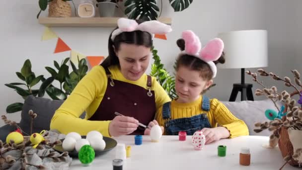 Zabawna Młoda Matka Uczy Szczęśliwą Córeczkę Farbować Dekorować Jajka Farbami — Wideo stockowe