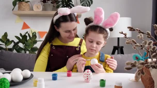 Заботливая Улыбающаяся Молодая Мать Маленькая Дочь Рисующие Яйца Сидящие Столом — стоковое видео