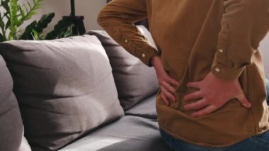 Evdeki kanepede sırtı ağrıyan, sırt ağrısı çeken, sırt ağrısı çeken, sırt ağrısı çeken, bel altı ve bel ağrısı çeken beyaz bir adamın kronik eklem sorunları var. Sırt ve omurga sorunları