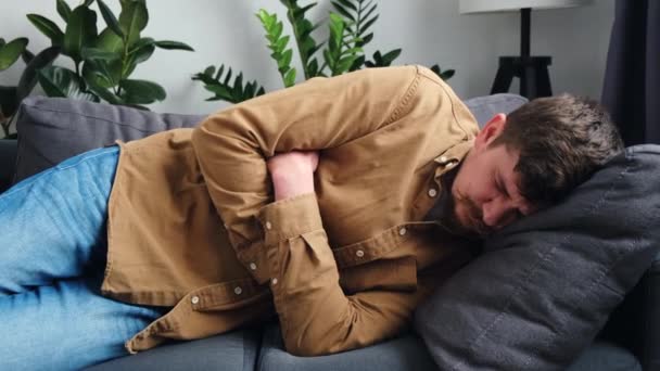 Нездоровий Молодий Чоловік Лежить Дивані Вдома Раптом Відчуває Сильний Біль — стокове відео