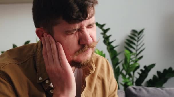 生病的年轻高加索男性 坐在沙发上 头痛医头 不健康的30多岁的悲伤男子患有痛苦的中耳炎 保健和耳鸣概念 — 图库视频影像