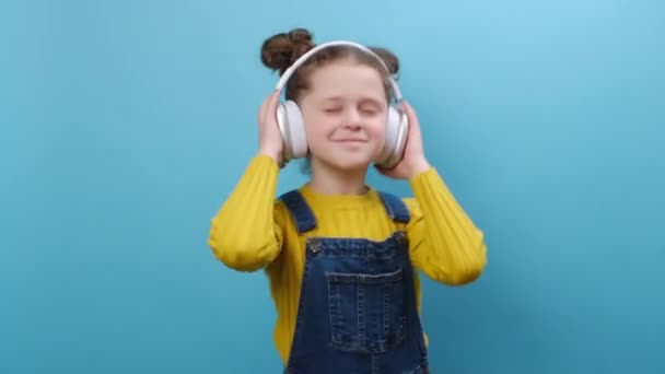 Portret Ładnej Dziewczynki Słuchającej Muzyki Słuchawkach Pozującej Niebieskim Tle Słodkie — Wideo stockowe
