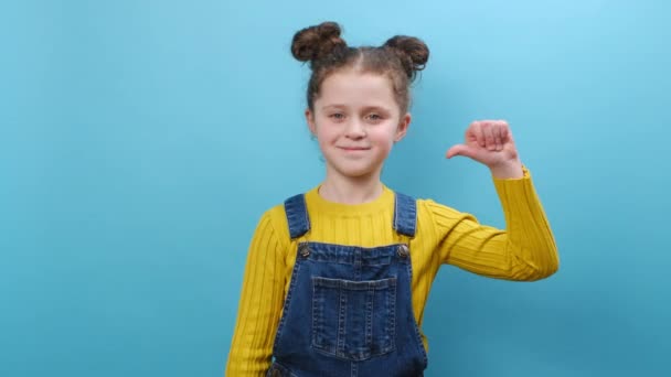 Портрет Щасливої Чарівної Дівчинки Яка Вказує Великі Пальці Себе Дивлячись — стокове відео