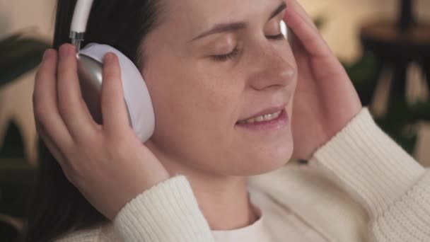 Detailní Záběr Veselou Mladou Bělošku Která Nosí Bezdrátová Sluchátka Poslouchá — Stock video