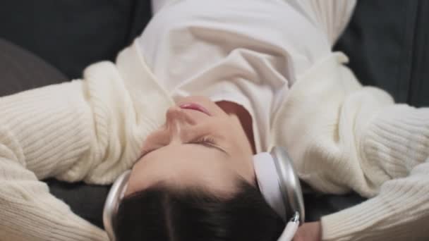 임신부 거실의 소파에서 헤드폰을 음악을 아름다운 미래의 어머니 인테리어 — 비디오