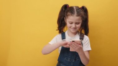 Ergen kız çocuğunun portresi web 'de yeni bir yazı yazarken, internette gezinirken, ararken, sosyal ağlara bağımlıyken, kablosuz cep telefonu bağlantısı 5G öneriyor, sarı arka planda izole edilmiş poz veriyor.