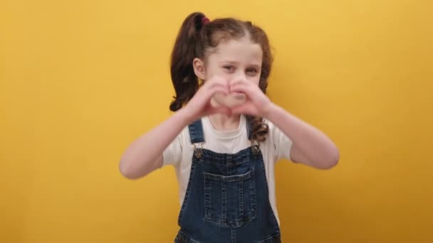 Πορτρέτο Ευτυχισμένη Αξιολάτρευτο Κοριτσάκι Επιδεικνύει Την Καρδιά Σημάδι Χέρια Χαμογελώντας — Αρχείο Βίντεο