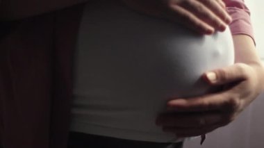 Hamile bir kadının çocuğuna bakarken kendini mutlu hissetmesi. Genç yaşta annenin karnına nazikçe dokunmasını bekliyoruz. Doğum öncesi bakım ve kadın hamileliği konsepti