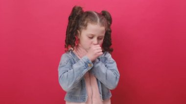 Sağlıksız çocuk öksürürken ağzı elle kapanıyor, hasta, alerji ya da viral enfeksiyon belirtileri hissediyor, kırmızı arka plan duvarında izole bir şekilde poz veriyor. Hastalık, grip, enfeksiyon konsepti