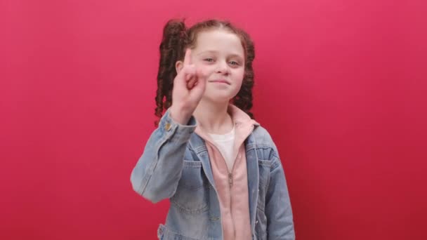 小さな女の子の子供の肖像画は興奮して笑顔とカメラに指を指して 幸運勝者を選択し 最高のあなたに示す スタジオで赤い色の背景の壁の上に孤立ポーズ おいお前 — ストック動画