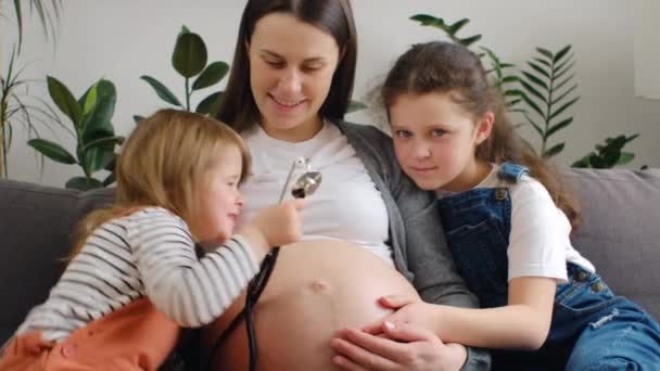 Meraklı Küçük Kızlar Hamile Anne Karnına Steteskop Uyguluyor Karnındaki Küçük — Stok video