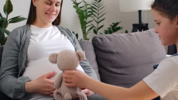 Fürsorgliche Junge Schwangere Mutter Und Verspielte Kleine Tochter Spielen Teddybär — Stockvideo