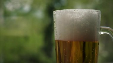 Taze cereyanı kapatın ya da temiz bardakta bira ve arka planda beyaz köpük olsun ya da yaz ormanı, kabarcıklar ve köpükler olsun. Kırsal, erkeksi, kaba, vahşi yaşam tarzı konsepti