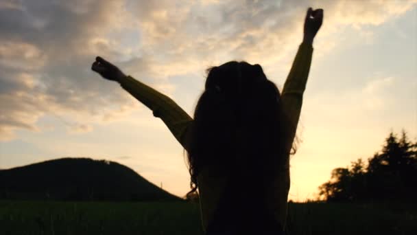 산등성이와 석양에 하늘을 배경으로 소녀의 실루엣 행복을 숭배와 주었다 낙관주의의 — 비디오
