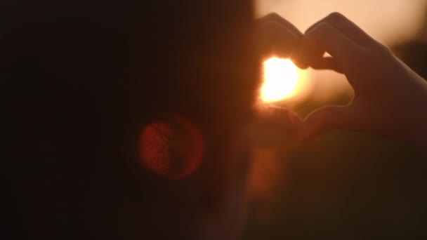 Селективный Фокус Маленькой Девочки Делающей Сердце Руками Фоне Красивого Заката — стоковое видео