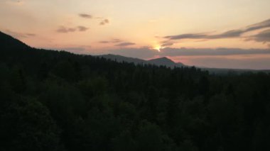 Destansı sinematik karanlık ve renkli günbatımında dağ zirvesinin hava görüntüsü. Gün batımında ya da şafak saatinde inanılmaz bir gökyüzü ile ufukta batar. Huzurlu doğa ve açık hava kamp havası.
