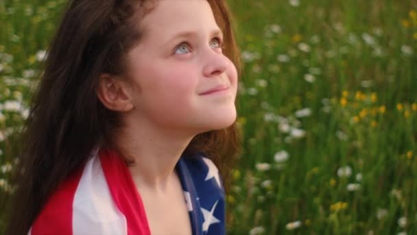 독립기념일 아래서 축하하는 소녀의 아이와 들판에서 국기를 가지고 있습니다 깃발에 — 비디오