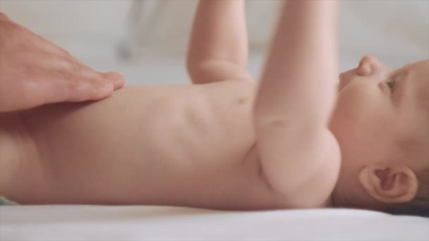 不知名的年轻父亲给可爱的小宝宝按摩的特写镜头 新生儿皮肤护理的概念 预防结肠炎 男人帮新生儿子按摩漂亮的高加索婴儿躺在后面 — 图库视频影像