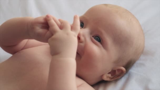 亲密的肖像可爱的新生儿独自躺在舒适的白色床上在家里 可爱的笑着的男婴躺在舒适的床单 医疗保健和儿科 婴儿期的概念上 — 图库视频影像
