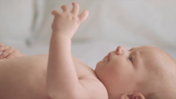 Seitliche Nahaufnahme Des Niedlichen Babys Das Auf Einem Bequemen Weißen — Stockvideo