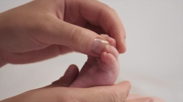 Заботливая Молодая Мама Массирует Детскую Ногу Лежа Удобной Кровати Дома — стоковое видео